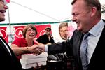Sabotage. Statsminister Lars Løkke Rasmussen (V) kom ved en kraftig opbremsning til at ødelægge Socialdemokraternes hindbærsnitter. Her gør han skaden god igen ved at overrække lokalformand Anette Stæhr (A) tre kasser nye snitter. Foto: Jacob Ehrbahn 