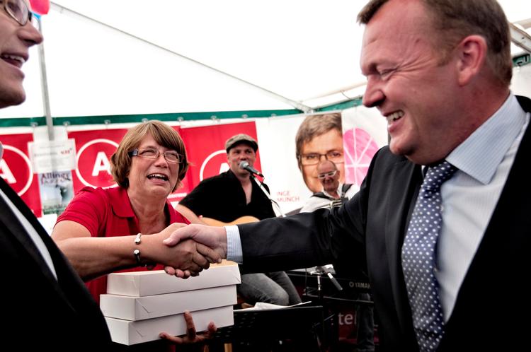 Sabotage. Statsminister Lars Løkke Rasmussen (V) kom ved en kraftig opbremsning til at ødelægge Socialdemokraternes hindbærsnitter. Her gør han skaden god igen ved at overrække lokalformand Anette Stæhr (A) tre kasser nye snitter. Foto: Jacob Ehrbahn 