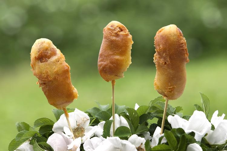 Majshunde. Den amerikanske hotdogvariant med pølser svøbt i friturestegt majsmelsdej kræver lidt snilde. Læg spyddene så vandret som muligt i gryden, ellers glider dejen af. 