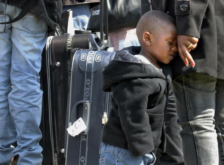 Rejse. En træt dreng læner sig mod sin mor efter at være ankommet til det vestlige Rumænien med en gruppe eritreanske flygtninge fra Libyen. 