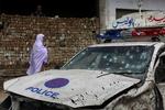 ANGREBSMÅL. Pakistansk politi og militær er ofte mål for terrorangreb. Her spadserer en kvinde forbi en politibil, der blev ødelagt af en vejsidebombe nær Peshawar i marts. 