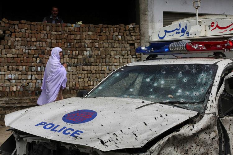 ANGREBSMÅL. Pakistansk politi og militær er ofte mål for terrorangreb. Her spadserer en kvinde forbi en politibil, der blev ødelagt af en vejsidebombe nær Peshawar i marts. 