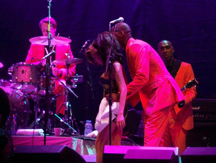 Konfus. En korsanger hjælper Amy Winehouse med at holde balancen under lørdagens koncert i Serbien. En koncert, der blev afbrudt efter to numre. 