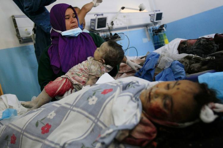 Død. En libysk læge fremviser ligene af et spædbarn og hvad der ser ud til at være en voksen kvinde på et hospital i Sabrata. De to døde, ifølge det libyske regime, sammen med endnu 17, da Nato ramte et landbrug i Surman. 