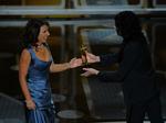 Værsgo. Susanne Bier ses her i Elise Gug-kjolen, mens hun modtager sin Oscar for årets bedste udenlandske film af komikeren Russell Brand. 
