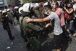 Urobetjente og demonstranter ser hinanden an i Athens gader. 