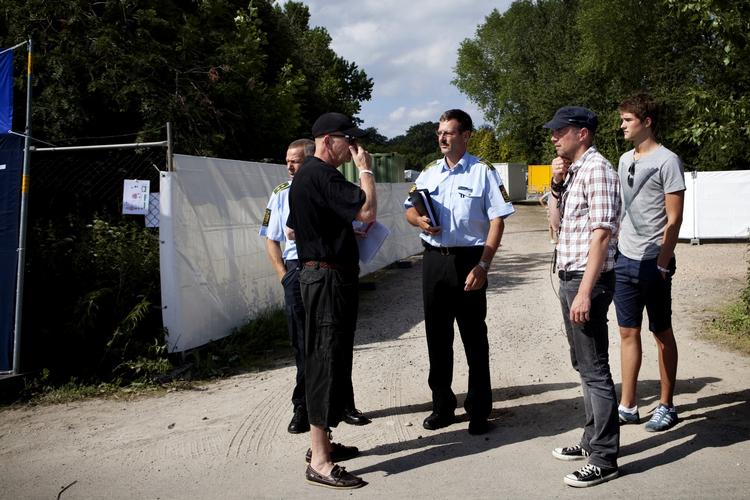 Vejbøvl. Keld Bjergegaard (til venstre) ejer grunden, hvor Love Camp er i gang. Her står han ved porten mellem Roskilde Festival og Love Camp sammen med Dan Warming fra politiet og medarrangør af Love Camp Frederik Raunstrup. 