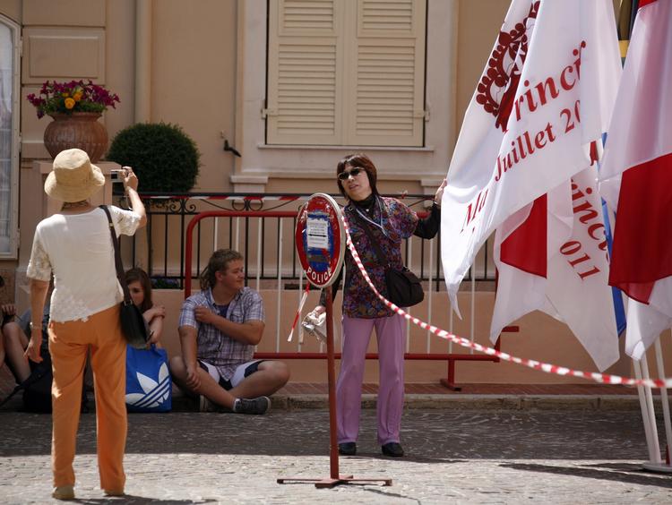 bryllupsforberedelse. Turister poserer foran nogle af de mange flag, der pynter op i Monaco. 