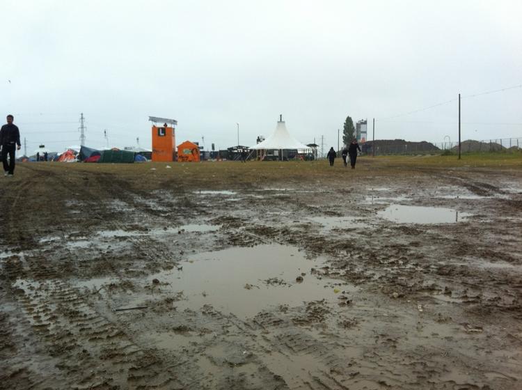 vådt. Det lysner ved middagstid, lover DMI. Men lige nu er det gummistøvletid på Roskilde Festival. 