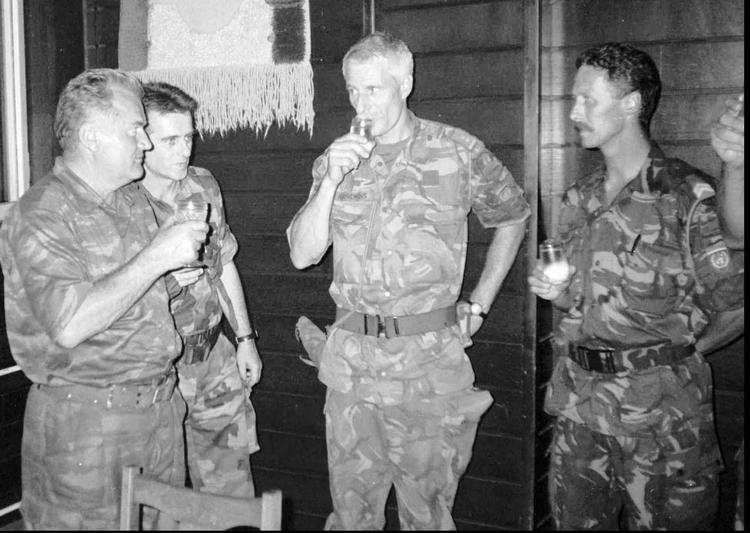 General Ratko Mladic (til venstre) drikker en skål med den hollandske chef for FN's fredsbevarende styrker i Bosnien i 1995, Tom Karremans (midt i billedet). Billedet er taget fem kilometer nord for Screbrenica, hvor Mladic på omkring samme tidspunkt befalde et folkemord på omkrng 8.000 bosniske muslimer. 