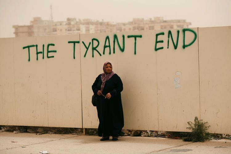 OPRØR. Modstanderne af Gaddafis styre gør fremskridt - og gennemfører ifølge britisk journalist tilsyneladende også aktioner i hovedstaden Tripoli. Kvinde venter ved mur i Benghazi, oprørernes hovedstad. 