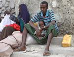 En nylig ankommet familie sidder ved registeringskontoret og venter på at blive lukket ind i Lejren. ( Jumbo organization, a local NGO, in Mogadishu, Somalia, ) 