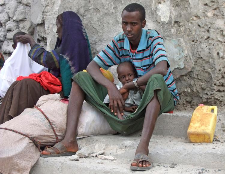 En nylig ankommet familie sidder ved registeringskontoret og venter på at blive lukket ind i Lejren. ( Jumbo organization, a local NGO, in Mogadishu, Somalia, ) 