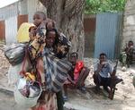 En kvinde ankommer her til Mogadishu fra det sydlige Somalia med sine ejendele og børn. (Foto: Abdi Warsameh/AP) 