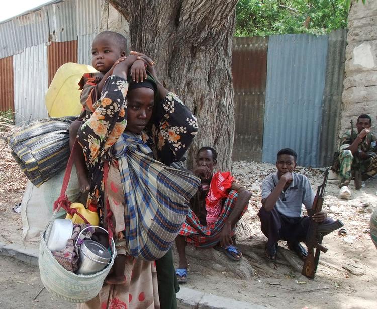 En kvinde ankommer her til Mogadishu fra det sydlige Somalia med sine ejendele og børn. (Foto: Abdi Warsameh/AP) 
