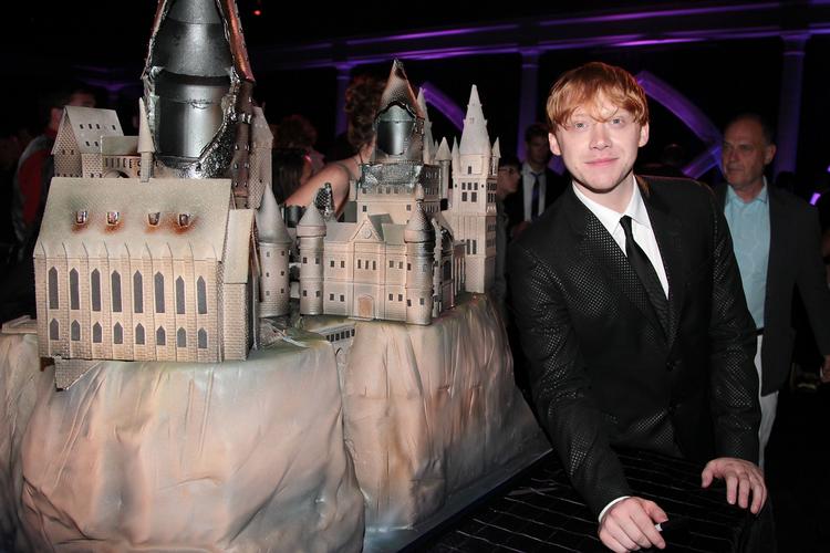Rupert Grint til premiere i New York foran en kage med form som Hogwarts. 