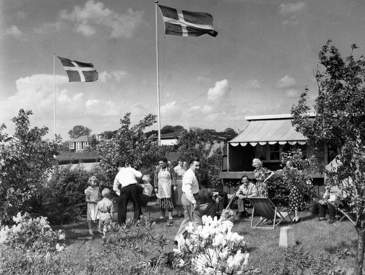 Idyl. Folk i udlandet forstår sjældent helt konceptet omkring Danmarks små kolonihaver. Et sommerhus i byen giver bare ikke umiddelbart mening, så det er bestemt værd at hive turisterne med en tur i kolonihaveland. Som eksempelvis her i en af Kløvermarkens mange små paradishaver. Her er vi i 1953, men de eksisterer stadig i bedste velgående. 