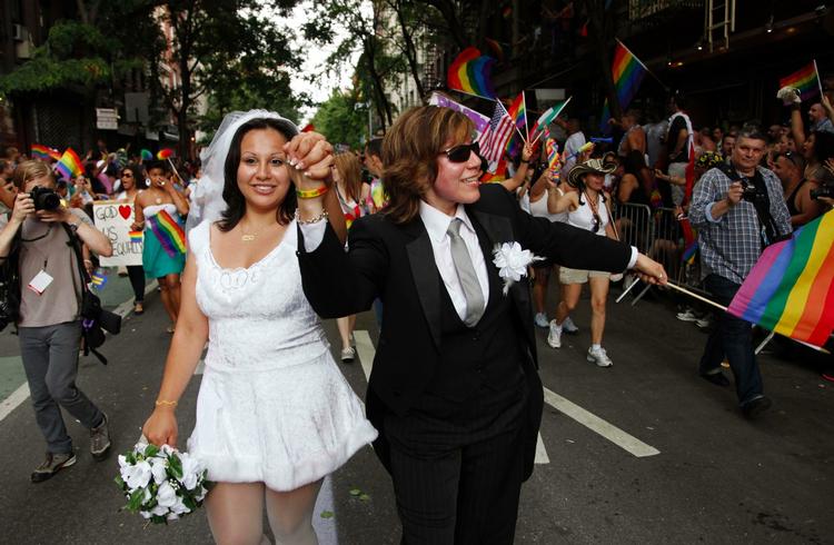 ÆGTEPAR. Paola Perez (tv.) og hendes partner Linda Collazo er klædt ud som brud og brudgom under den årlige Homo-parade i Greenwich Village i New York i juni. 