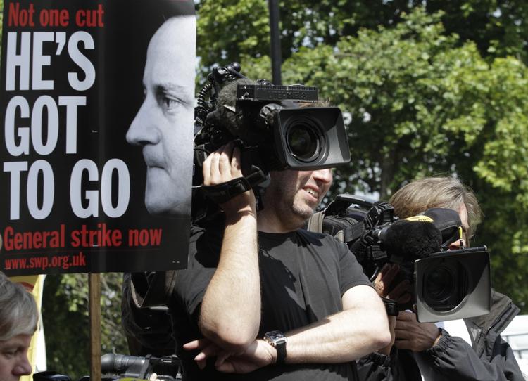 Stormvejr. Londons politi er i krise. Men det samme gælder premierminister David Cameron, som demonstranter her opfordrer til at gå af. 