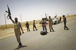 krig. Libyske oprørere hilser ved en kontrolpost omkring 20 kilometer vest for byen Ajdabiya 19. juli. 