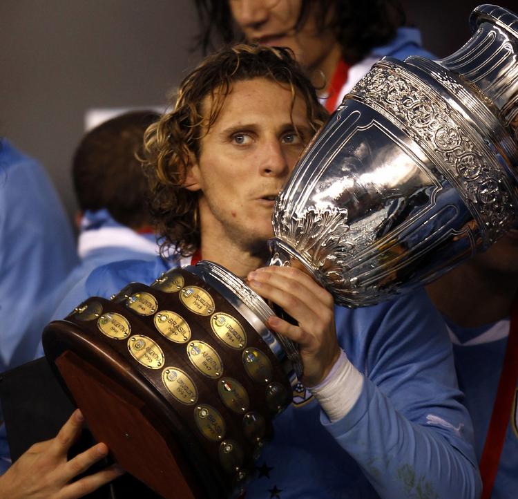 historieskriver. Diego Forlan kysser pokalen efter at have fortsat en flot familietradition med sejre i Copa America. 