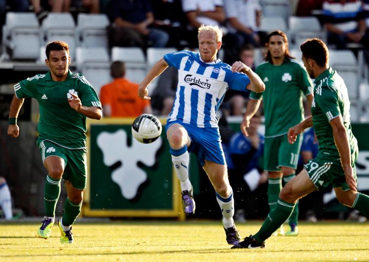 pågående. OB’ernes Hans Henrik Andreasen (i stribet) forsøger at slippe gennem Sotiris Ninis og Kostas Katsouranis fra Panathinaikos. Foto: Jens Dresling 