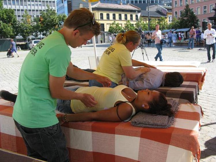 Sorghjælp. Medlemmer af Scientology demonstrerer, hvordan man giver en 'nerve assist'. Forrest på et andet medlem, bagerst på en journalist, der skal lave en historie om boden. Det er Heidi Brandt i gult. 
