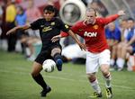 revanche. Manchester Uniteds Wayne Rooney (th) i kamp med FC Barcelonas Jonathan dos Santos under testkampen i USA. 