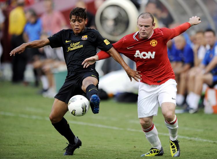 revanche. Manchester Uniteds Wayne Rooney (th) i kamp med FC Barcelonas Jonathan dos Santos under testkampen i USA. 