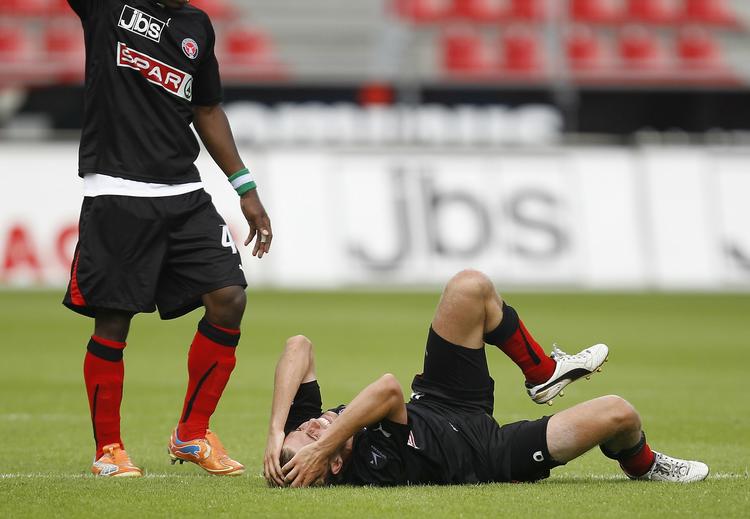 skadet. FC Midtjyllands Jakob Poulsen måtte søndag bide i græsset efter en hensynsløs tackling af Lyngbys Morten Bertolt. 