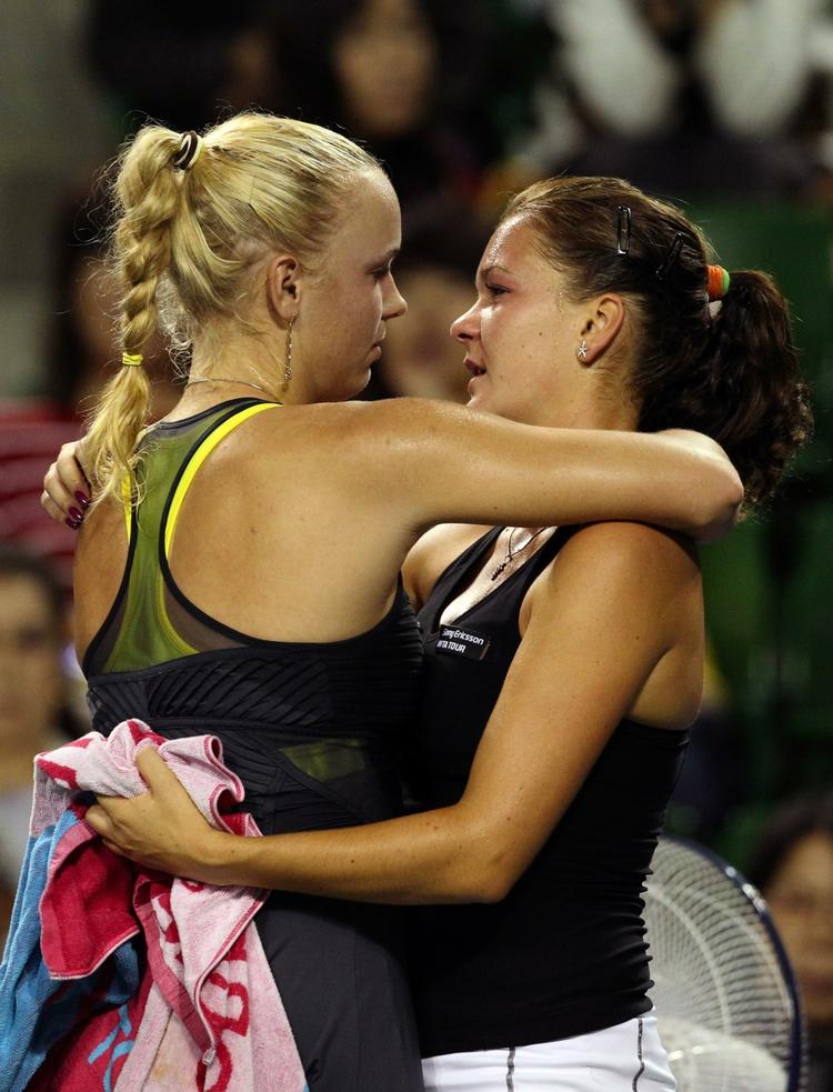 ude. Caroline Wozniacki trøster veninden Agnieszka Radwanska, da polakken må give op på grund af en fodskade i kvartfinalen i Japan for en uge siden. Arkivfoto. 
