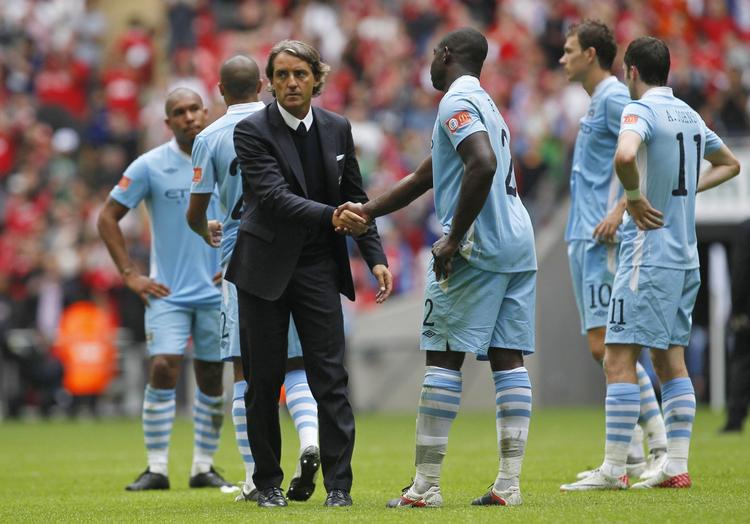 ærkerivaler. Manchester Citys manager Roberto Mancini hilser på sine spillere efter nederlaget til Manchester United. 