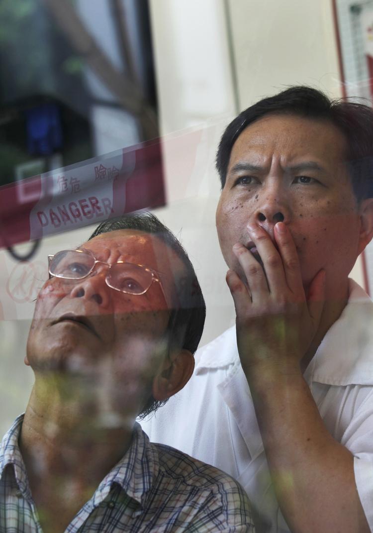 Opmærksomhed. Nogle investorer holder øje med kurserne på børsen i Hong Kong. Dagen endte med et minus på 3,1 procent. 
