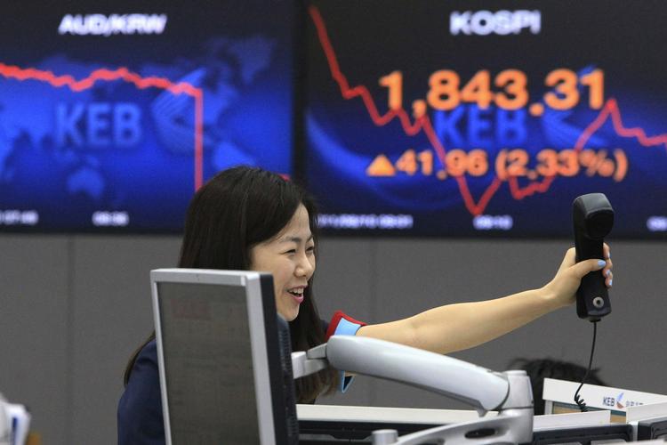 Glæde. De asiatiske markeder er startet i plus, efter gårsdagens melding fra den amerikanske nationalbank om, at den holder den lave rente i ro de næste to år. Her en smilende aktiehandler på børsen i Sydkorea. 