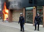 OPTØJER. Betjente i kampuniform foran brændende butik i Manchester. 