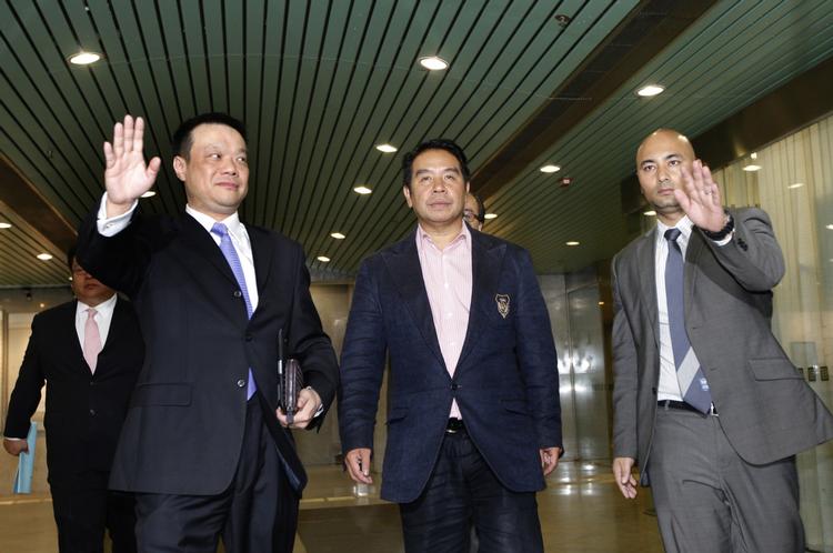 anklaget. Indtil videre må Birmingham City-ejeren Carson Yeung (i midten) ikke forlade Hongkong. 