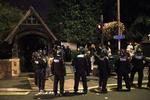 Konfrontation. Politi har for at forebygge uroligheder omringet en gruppe personer foran en kirke i London-bydelen Eltham. 
