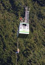FANGET. Turister sad fast i alperne, da en paraglider styrtede ind i kablerne i går. Her hjælpes passagerer ned fra 50-meters højde. Yderligere 20 mennesker måtte vente en hel nat, før de kunne komme ned fra deres kabelbil,som var fanget i 80-meters højde. 