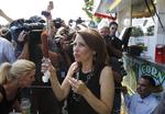 Optakt. Michelle Bachmann - der her nyder en lokal specialitet, en majspølse - håber at gøre det godt i aftenens 'straw poll'. 