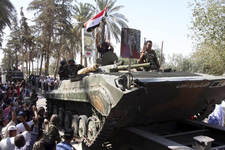 Glæde? Det er ikke mange billeder, der kommer ud fra Syrien. Dette, fra i tirsdags, er fra en propagandatur arrangeret af styret, som angiveligt viser glade syriske soldater og beboere i byen Deir el-Zour i den østlige del af landet. 