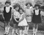 1927. Arlette Andersen som barn (hvid kjole i midten) med kusiner og fætre i det centrale Paris. Micheline og Genvieve (yderst til henholdsvis venstre og højre) blev begge dræbt i Auschwitz. François, der holder Arlette, blev dræbt som modstandsmand. Madelaine (nummer 2 fra højre) bor i dag i Paris. Foto fra bogen: Privat 
