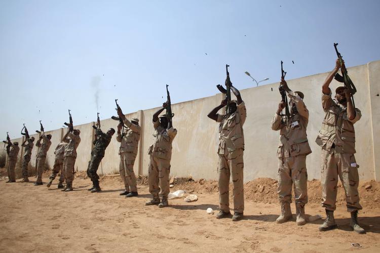 Afskedssalut. Oprørere affyrer skud i forbindelse med en begravelse i Benghazi i går, hvor fire rebeller, der faldt i forbindelse med kampene ved Brega, blev stedt til hvile. 