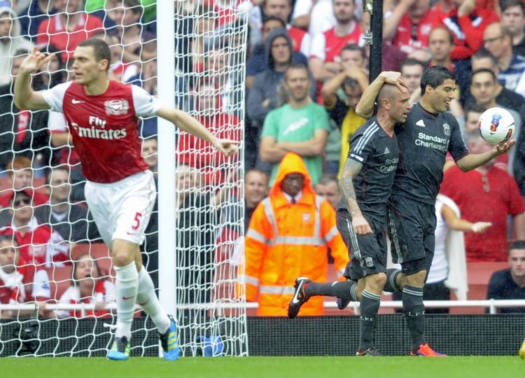 Nedtur. Arsenal's Thomas Vermaelen protesterer, mens de to superindskiftere Raul Meireles og Luis Suarez fejrer scoringen til 2-0. 