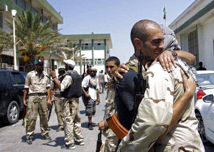 Fremtid. Libyske oprørere omfavnede hinanden efter at have erobret en af Gaddafis baser forleden. Nu venter alle i spædning på en afslutning af konflikten. 