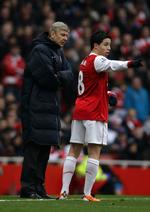 undersøges. Arsenals træner Arsene Wenger konfererer med Samir Nasri under en kamp i Premier League. 
