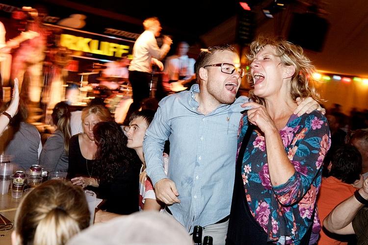 Feststemning. Musikken på Pustgervig kalder på fællesang og gemytligt samvær. En populær cocktail, som gør, at teltet er pakket med mennesker. 