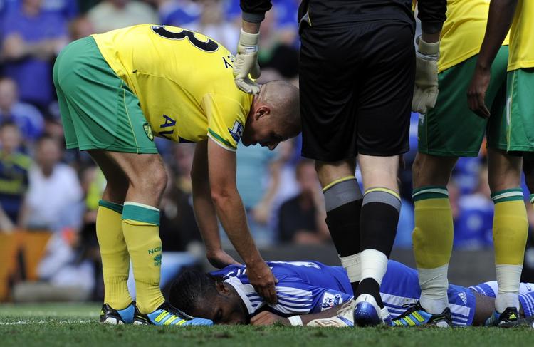 bevidstløs. Didier Drogba ligger bevidstløs i græsset efter den uhyggelige knockout. 