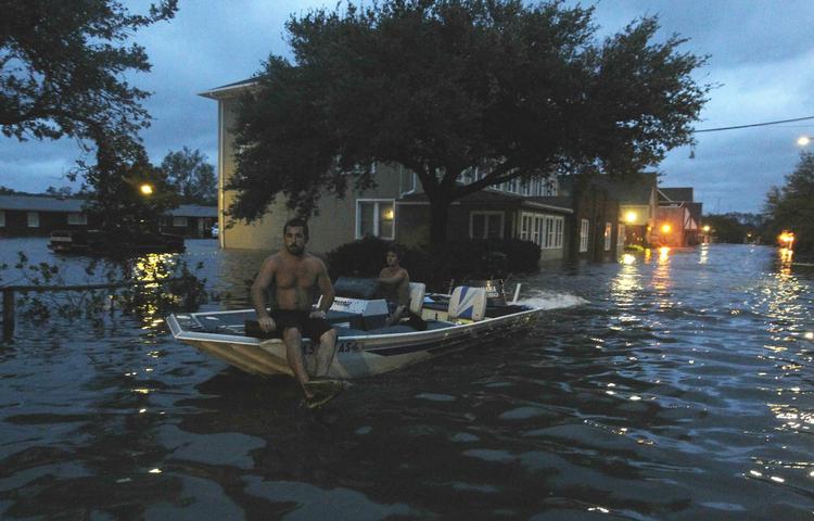 vandstigninger. To mænd inspicerer en gade i Manteo, North Carolina, der er oversvømmet efter orkanen Irene. 
