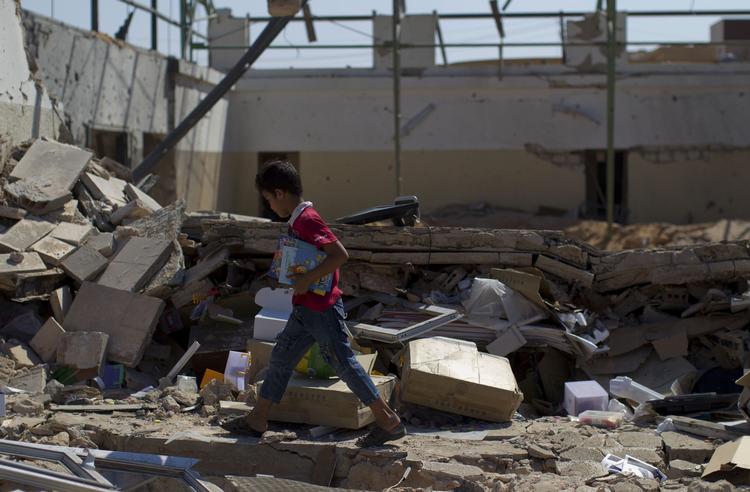 OPRØR. Dreng går gennem bomberamt skole i Tripoli. Nu forbereder FN en mission, der skal bidrage til sikkerhed og demokrati i landet. 