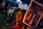 Protester. En eksiltibetaner holder et portræt af den munk, der døde 15. august af en selvafbrænding. 